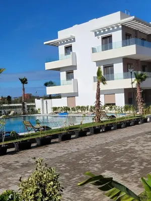 a building with a swimming pool in front of a building at heaven beach in Sidi Rahal