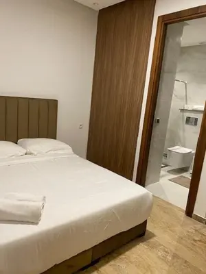 a bedroom with a white bed and a bathroom at heaven beach in Sidi Rahal