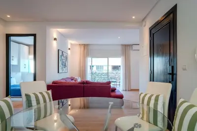 a living room with a glass table and a couch at Appartement luxueux &chaleureux au cœur de Rabat in Rabat