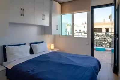 a bedroom with a blue bed and a window at Appartement luxueux &chaleureux au cœur de Rabat in Rabat