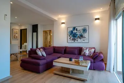 a living room with a purple couch and a table at Appartement luxueux &chaleureux au cœur de Rabat in Rabat