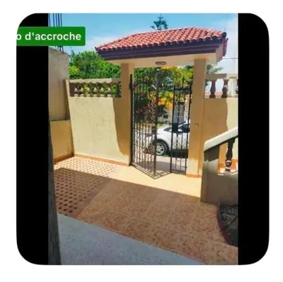 a gate to a house with a car behind it at Dar Khnata in Temara