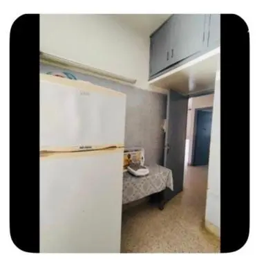 a kitchen with a white refrigerator and a table at Dar Khnata in Temara