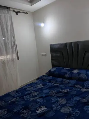 a bedroom with a blue bed with a black head board at Havre de paix in Rabat
