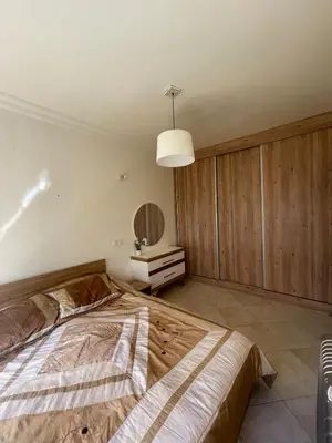 a bedroom with a large bed and a mirror at Harhoura Sea view apartment with green spaces and a pool in El Harhoura