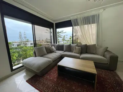 a living room with a couch and a coffee table at Harhoura Sea view apartment with green spaces and a pool in El Harhoura
