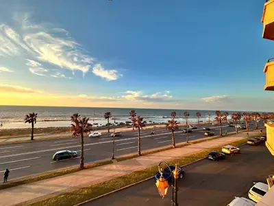a street with cars driving down a road next to the beach at 2BR Sea View Apartment - Balcony I Parking in Rabat
