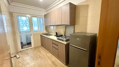 a small kitchen with a refrigerator and a stove at 2BR Sea View Apartment - Balcony I Parking in Rabat