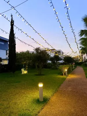 a pathway with lights in a park at night at Prestigia Golf City Bouskoura in Bouskoura