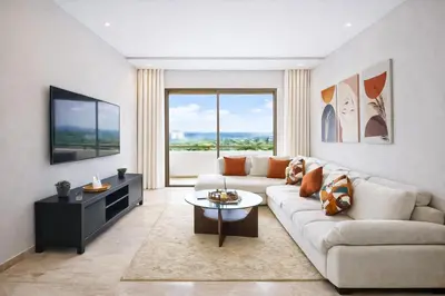 a living room with a couch and a large window at Modern Cozy Apartment in Prime Location in Nouaceur