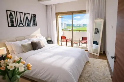 a bedroom with a large white bed and a balcony at Modern Cozy Apartment in Prime Location in Nouaceur