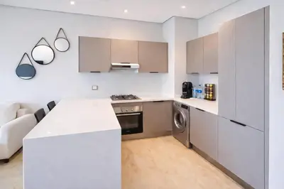 a kitchen with white cabinets and a white counter top at Modern Cozy Apartment in Prime Location in Nouaceur