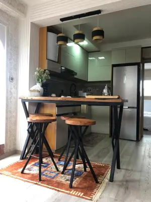 a kitchen with a large wooden table and stools at Chez Abir in Rabat