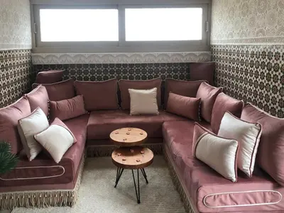 a brown leather couch in a room with pillows at Chez Abir in Rabat