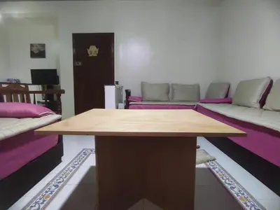 a living room with a table and a couch at Cosy appart 1min de casanearshore & Zinit in Casablanca