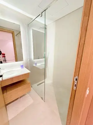 a bathroom with a glass shower and a sink at Havre de paix chic avec terrasse Maarif Palmier Casablanca in Maarif