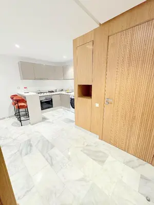 a kitchen with a large tile floor and wooden cabinets at Havre de paix chic avec terrasse Maarif Palmier Casablanca in Maarif