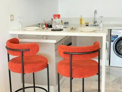 two red chairs in a kitchen with a sink at Havre de paix chic avec terrasse Maarif Palmier Casablanca in Maarif