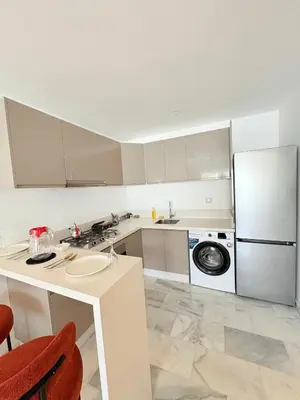 a white kitchen with a refrigerator and a sink at Havre de paix chic avec terrasse Maarif Palmier Casablanca in Maarif