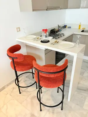 a kitchen with two chairs and a white counter at Havre de paix chic avec terrasse Maarif Palmier Casablanca in Maarif