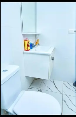 a white bathroom with a toilet and a sink at Magnifique studio disponible sur roche noire in Casablanca