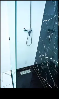 a shower with a glass door with a black counter top at Magnifique studio disponible sur roche noire in Casablanca