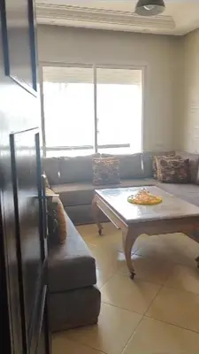 a living room with a table and a couch at Garden Beach in Sidi Rahal