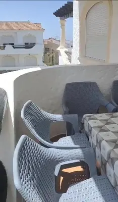 a pair of chairs sitting on a balcony at Garden Beach in Sidi Rahal
