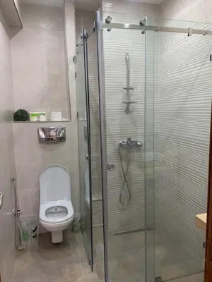 a bathroom with a toilet and a glass shower at Beach Ain Diab - Beautiful Apt in Bourgogne in Casablanca