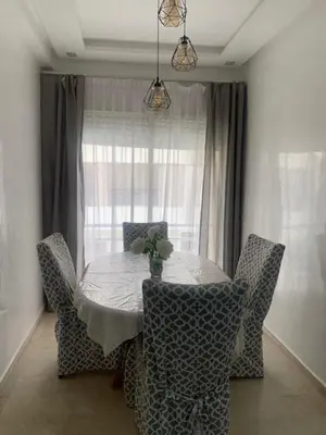 a dining room table with chairs and a window at Beach Ain Diab - Beautiful Apt in Bourgogne in Casablanca