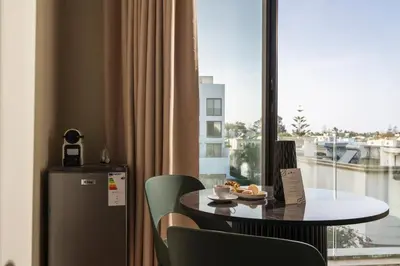a table and chairs in a room with a window at Oasis Residence by GoodMove - Casablanca in Casablanca