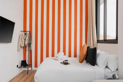 a bedroom with a white bed with an orange striped wall at Oasis Residence by GoodMove - Casablanca in Casablanca
