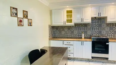 a kitchen with white cabinets and a counter top at Elegant cultural 2-bedroom apartment in central Casablanca in Casablanca