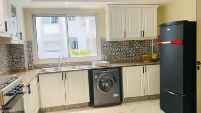 a kitchen with a black refrigerator and a washing machine at Elegant cultural 2-bedroom apartment in central Casablanca in Casablanca