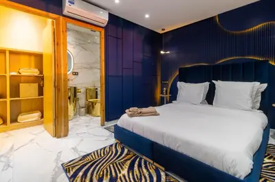a bedroom with a large bed and a blue wall at Casablanca Luxury Penthouse with Jacuzzi & Views in Casablanca
