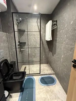 a bathroom with a shower and a black toilet at Havre moderne et lumineux calme avec parking in Casablanca