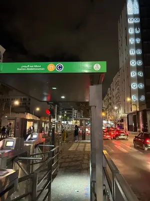 a green sign on a city street at night at Havre moderne et lumineux calme avec parking in Casablanca