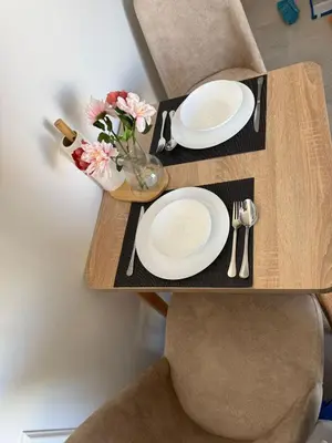 a wooden table with two plates and a vase of flowers at Havre moderne et lumineux calme avec parking in Casablanca