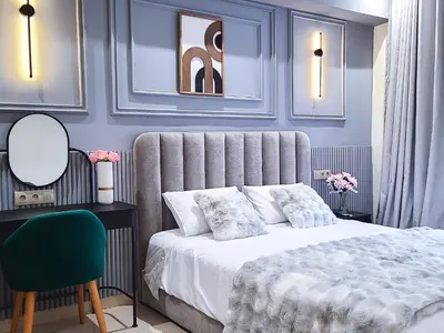 a bedroom with a bed and a mirror and a chair at Prestige appartement centre Agdal Rabat in Rabat