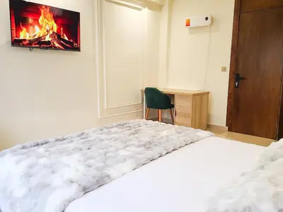 a bedroom with a bed and a fire in the wall at Prestige appartement centre Agdal Rabat in Rabat