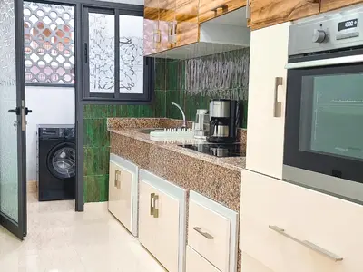 a kitchen with a sink and a counter with a microwave at Prestige appartement centre Agdal Rabat in Rabat