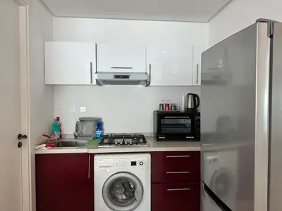 a kitchen with a washing machine and a microwave at Chic central Stay in Agdal in Rabat