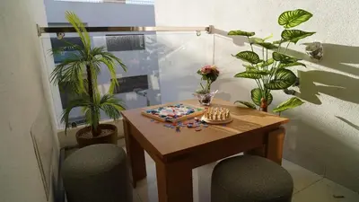a table with two chairs and a table with plants at Bel appartement, piscine intérieure et extérieure in Temara