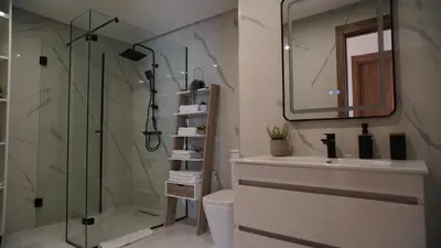 a bathroom with a shower and a toilet and a sink at Bel appartement, piscine intérieure et extérieure in Temara