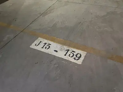a white sign on a sidewalk with a street at Bel appartement, piscine intérieure et extérieure in Temara