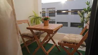 a wooden table and two chairs in a room at Bel appartement, piscine intérieure et extérieure in Temara