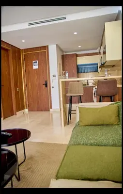 a living room with a couch and a kitchen at Cosy studio disponible sur maarif princesses in Casablanca