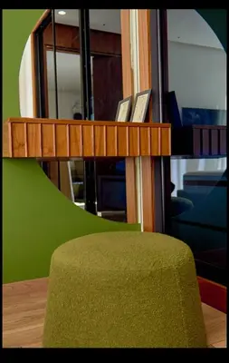 a green ottoman sitting next to a wooden shelf at Cosy studio disponible sur maarif princesses in Casablanca