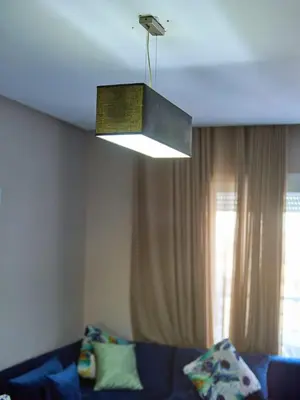 a light hanging over a couch in a living room at Joli studio disponible sur maarif boulevard danfa in Casablanca