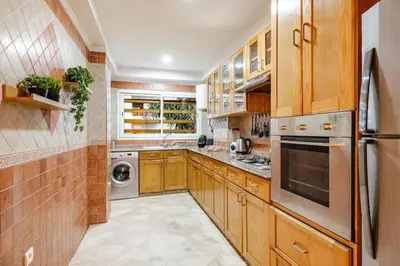 a kitchen with wooden cabinets and a stainless steel refrigerator at Moderne, 2 CH, Fibre optique, AC Garage Ascenseur in Rabat